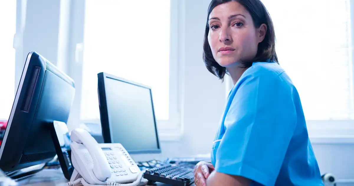 Médico PJ e secretária em clínica moderna, discutindo a contratação de secretária para clínica em 2026