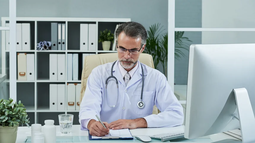 Médico sênior revisando documentos fiscais sobre Reforma Tributária 2026 · PleniHub Contabilidade São José dos Campos